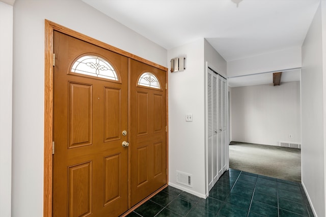 foyer entrance with dark tile patterned flooring