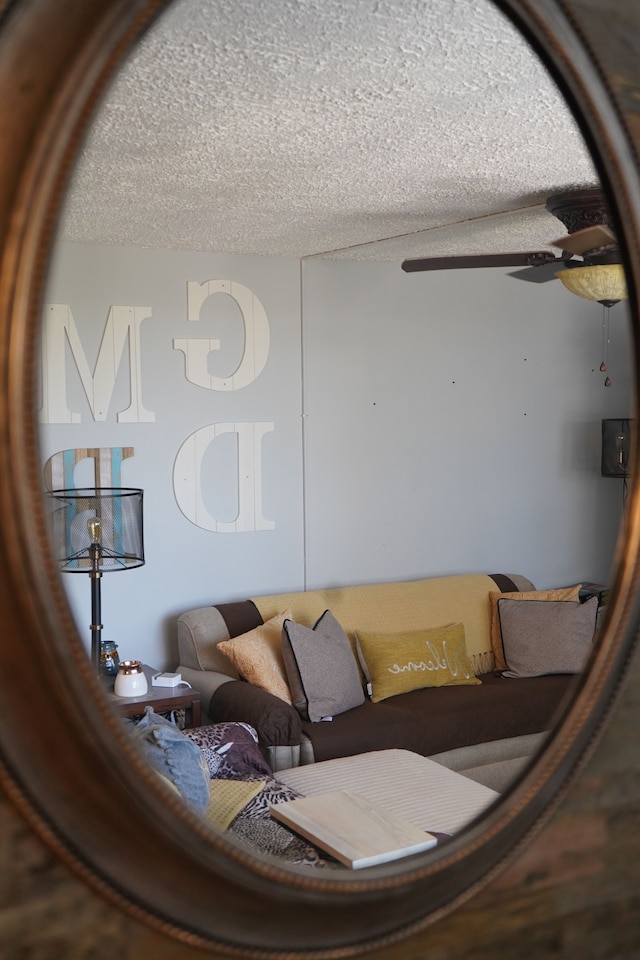 living room with a textured ceiling and ceiling fan