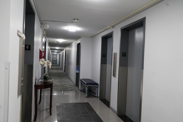 hall featuring elevator and tile patterned floors