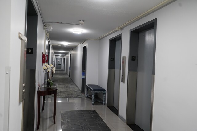 8900 E Jefferson Ave Unit 624, Detroit, MI 48214 - corridor with elevator and light tile patterned floors