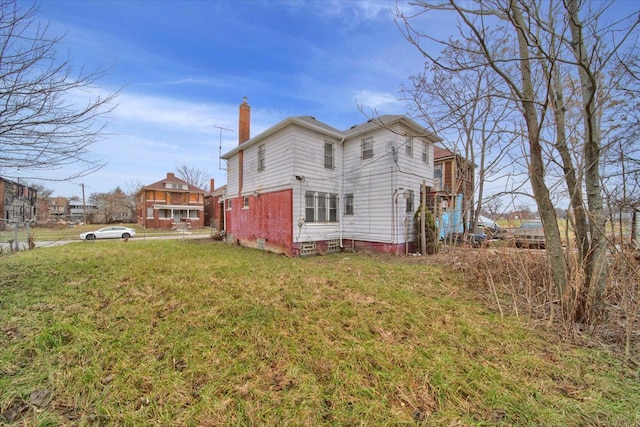 rear view of house featuring a yard