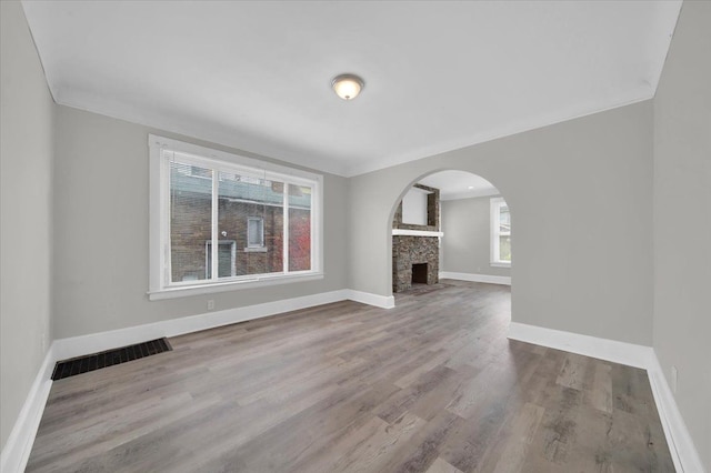 unfurnished living room featuring a wealth of natural light, a fireplace, and light wood-type flooring