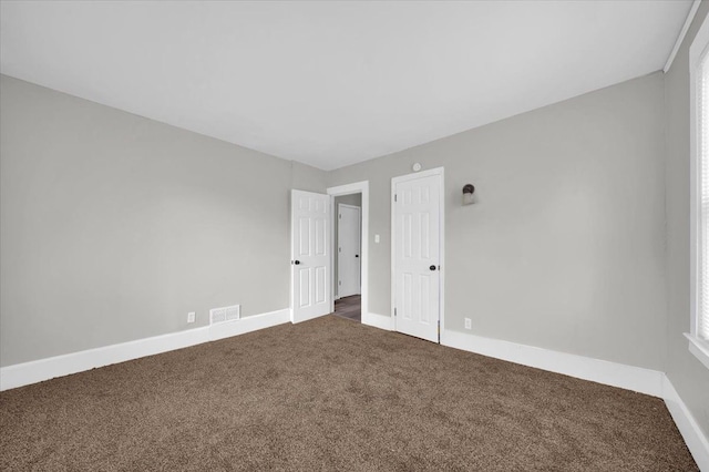 empty room with dark colored carpet