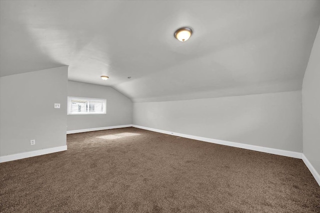 bonus room featuring dark carpet and lofted ceiling