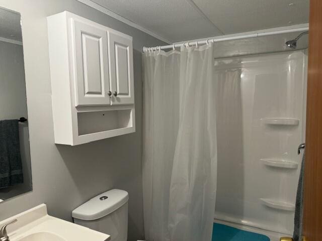 bathroom with a shower with curtain, toilet, vanity, and ornamental molding