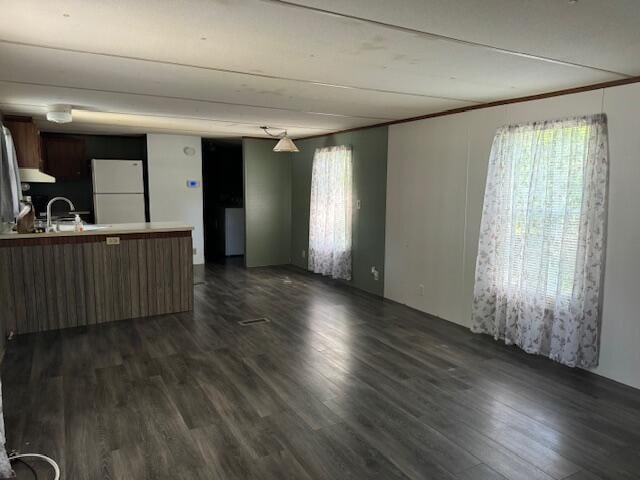 unfurnished living room featuring dark hardwood / wood-style floors and sink