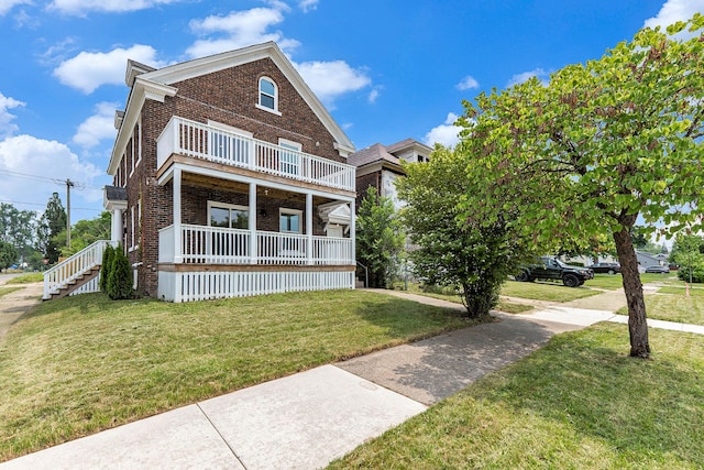 view of front of property featuring a balcony and a front lawn