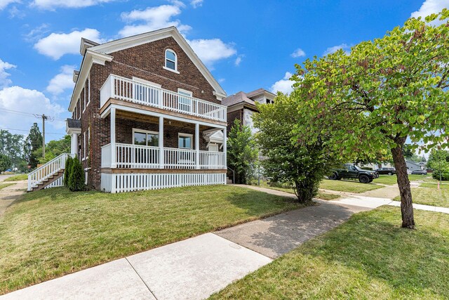 392 Philip St, Detroit, MI 48215 - view of front facade with brick siding, a balcony, a front yard, and a porch
