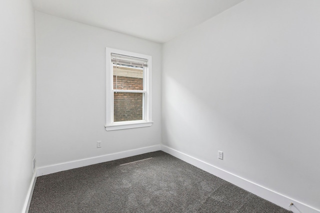 empty room with dark colored carpet