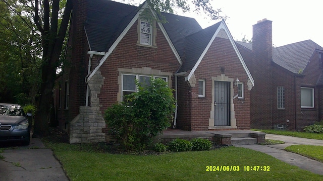 tudor home featuring a front lawn