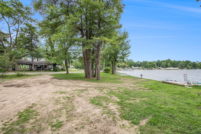 view of yard with a boat dock and a water view