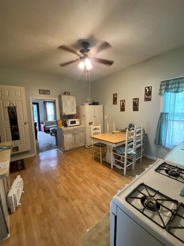 kitchen featuring ceiling fan, light wood-type flooring, white appliances, and a wealth of natural light