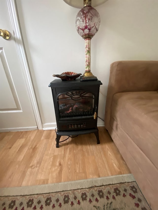 interior details with a wood stove and hardwood / wood-style flooring