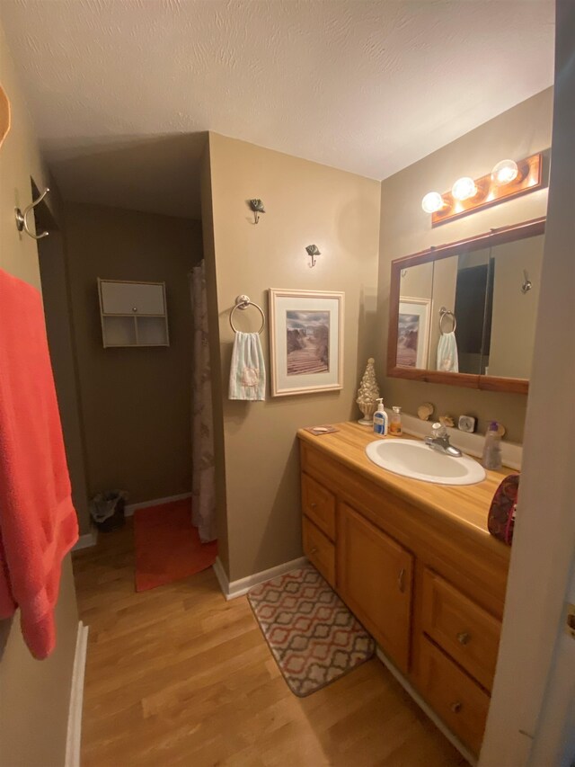 bathroom featuring hardwood / wood-style flooring, vanity, and a textured ceiling