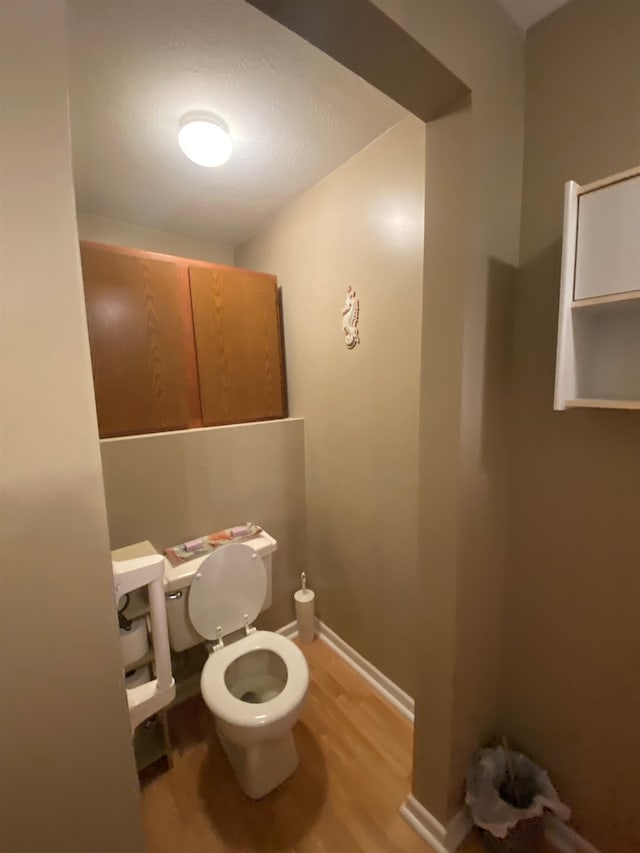 bathroom with hardwood / wood-style floors and toilet