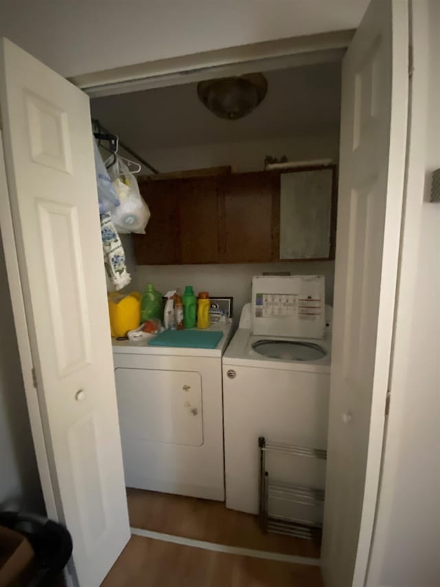 laundry area featuring cabinets, dark wood-type flooring, and independent washer and dryer