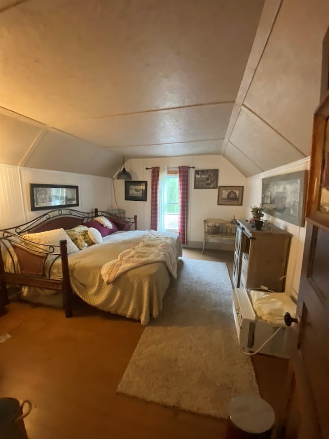 bedroom featuring dark carpet and lofted ceiling