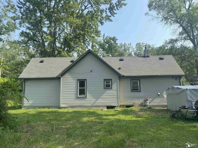 rear view of property with a yard