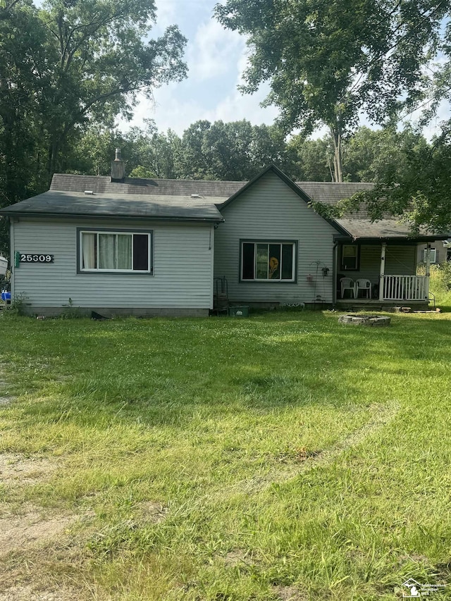 rear view of property featuring a yard