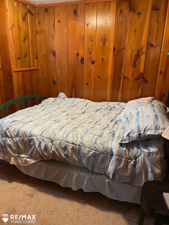 bedroom featuring carpet floors and wooden walls