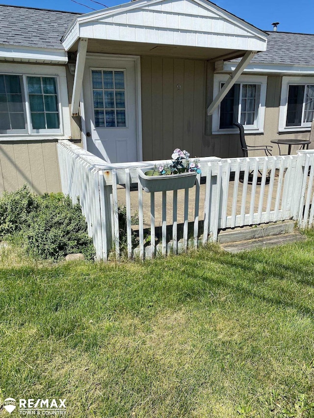 entrance to property with a wooden deck and a yard