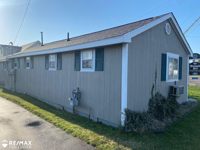 6344 W Houghton Lake Rd, Houghton Lake, MI 48629 - view of side of home with a shingled roof and ac unit