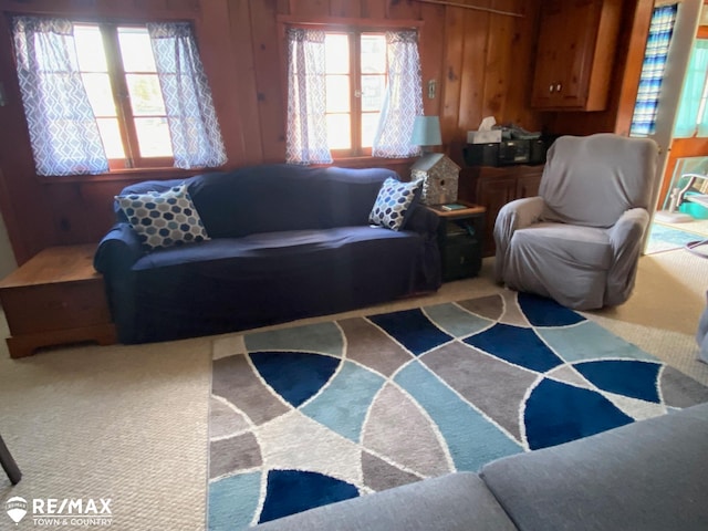 living room featuring carpet flooring and wooden walls