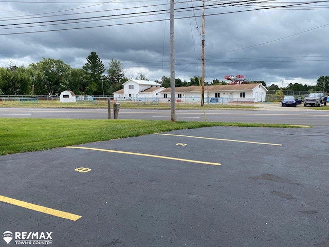 view of parking with a lawn