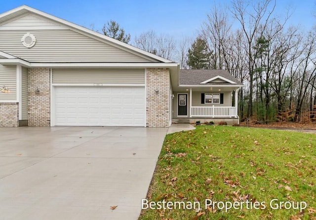 single story home with covered porch, a garage, and a front yard