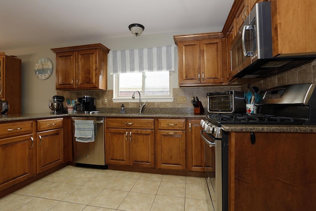 807 War Bonnet Dr, Tecumseh, MI 49286 - kitchen featuring light tile patterned flooring, backsplash, a sink, brown cabinets, and stainless steel appliances