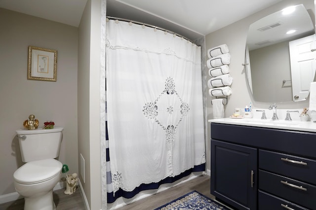 807 War Bonnet Dr, Tecumseh, MI 49286 - full bath featuring toilet, vanity, wood finished floors, and visible vents