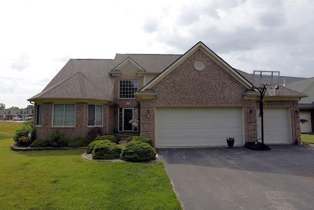 807 War Bonnet Dr, Tecumseh, MI 49286 - view of front of home with an attached garage, brick siding, a front lawn, driveway, and a shingled roof