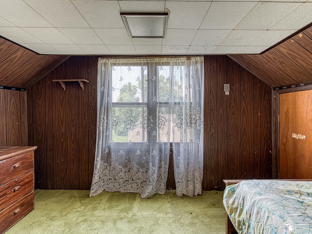 bonus room with wood walls, light colored carpet, and vaulted ceiling