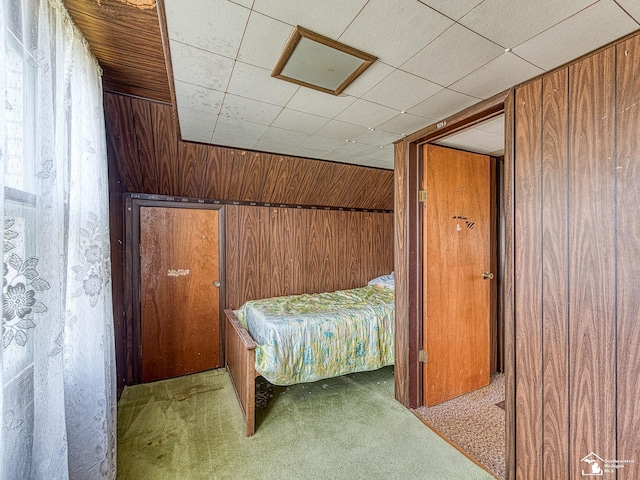 carpeted bedroom with wooden walls