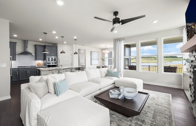 living room featuring ceiling fan with notable chandelier and dark hardwood / wood-style flooring