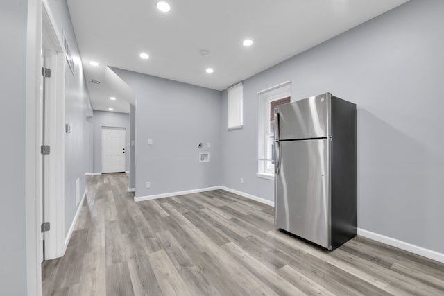 kitchen featuring stainless steel refrigerator, white cabinetry, and light hardwood / wood-style floors