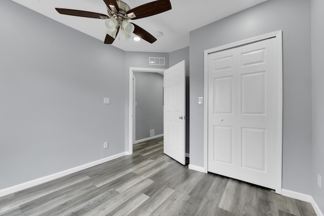 unfurnished bedroom featuring a closet, light hardwood / wood-style floors, and ceiling fan