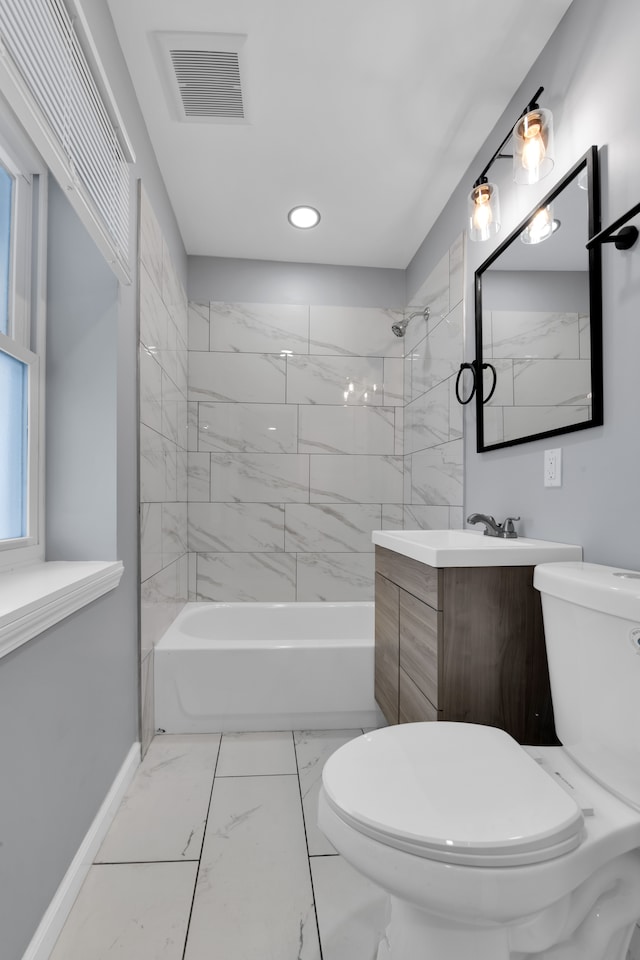 full bathroom featuring vanity, toilet, and tiled shower / bath