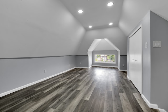 bonus room with dark wood-type flooring and lofted ceiling