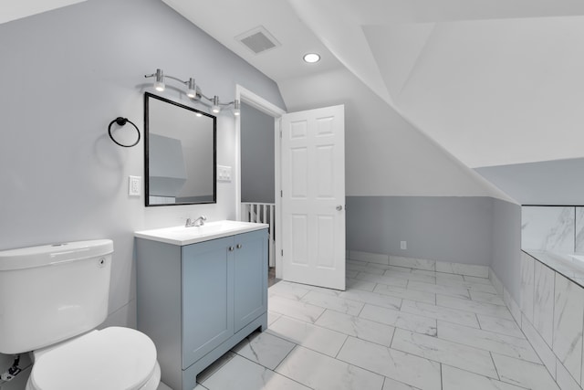 bathroom with vanity, toilet, and lofted ceiling