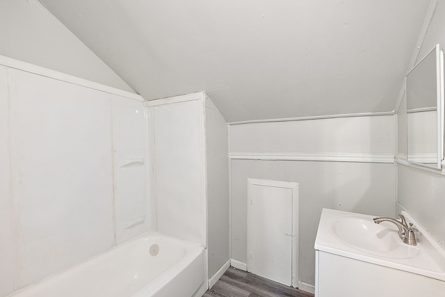 bathroom featuring hardwood / wood-style floors, vanity, shower / bath combination, and lofted ceiling