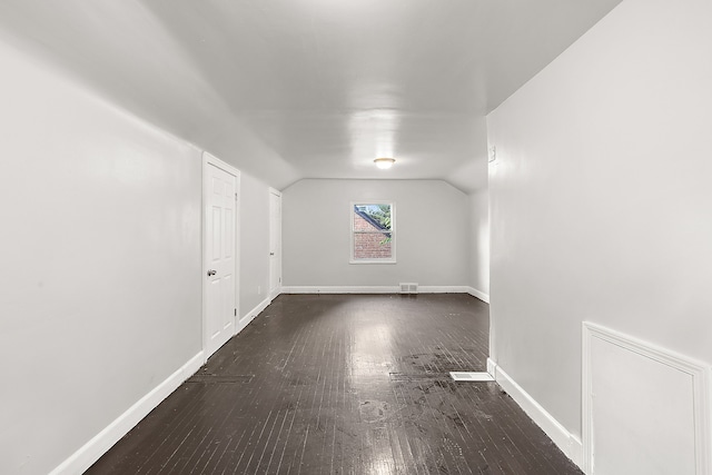 interior space with dark hardwood / wood-style flooring and vaulted ceiling