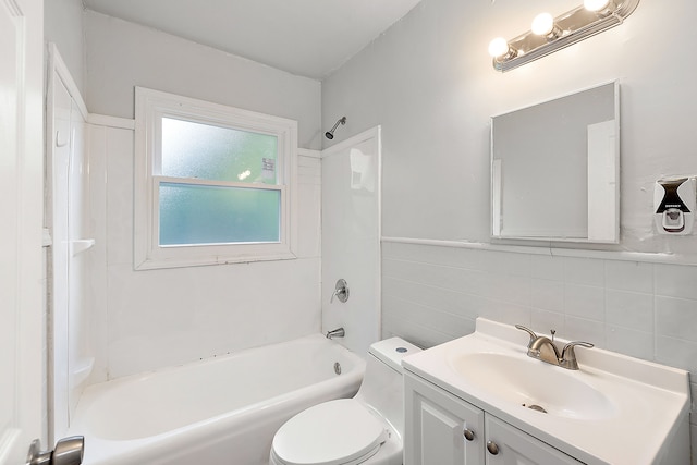 full bathroom with vanity, shower / bath combination, toilet, and tile walls