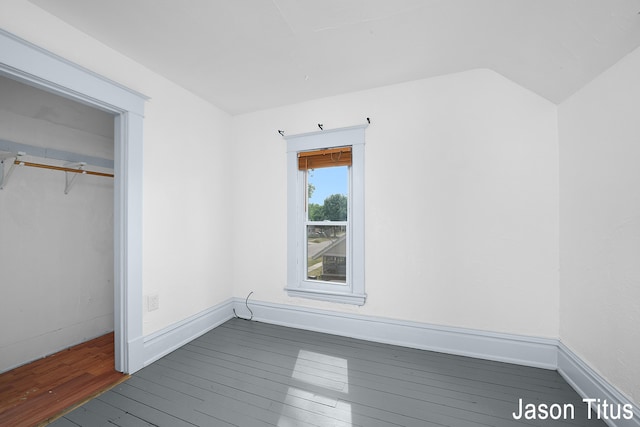 unfurnished bedroom featuring vaulted ceiling and dark wood-type flooring