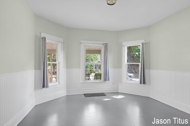 unfurnished room with dark wood-type flooring and a healthy amount of sunlight