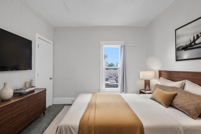 bedroom featuring dark colored carpet and ornamental molding