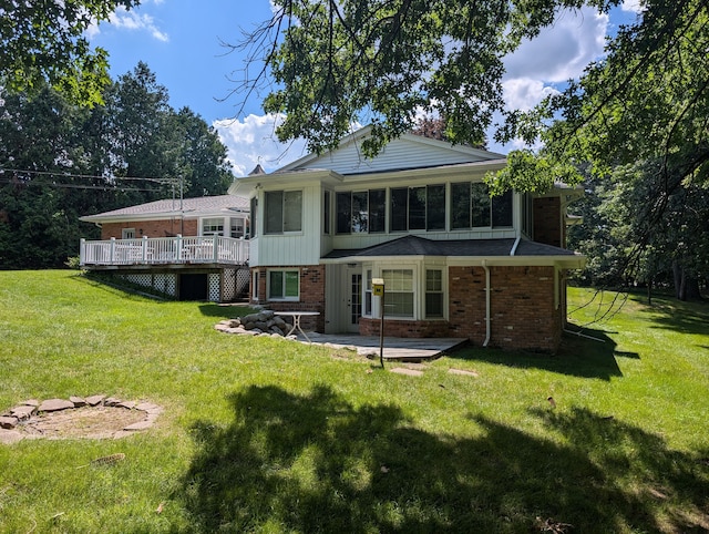 back of property featuring a yard, a patio, and a wooden deck