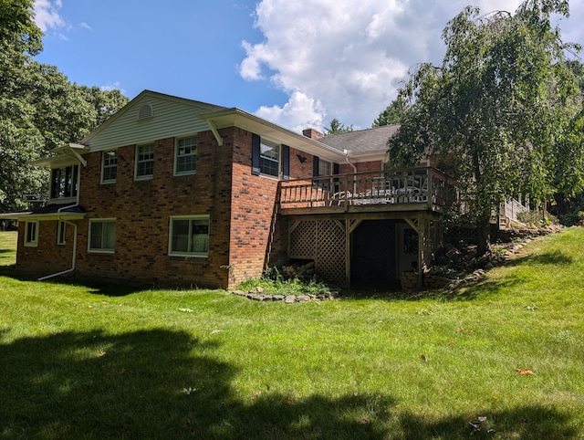 rear view of house featuring a deck and a lawn