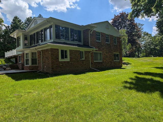 rear view of house with a lawn and a sunroom