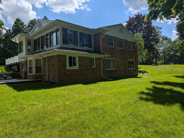 3641 Green Lake Rd, West Bloomfield, MI 48324 - view of home's exterior featuring a sunroom, brick siding, and a yard